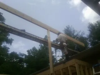 Carpenter setting a ridge beam over a new addition frame — Ice Dam Removal by Roofing Brothers in Salt Lick