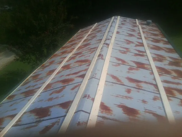 Rusted metal roof panels with new wood purlins before replacement — Storm Damage Roof Repair in Salt Lick by Roofing Brothers