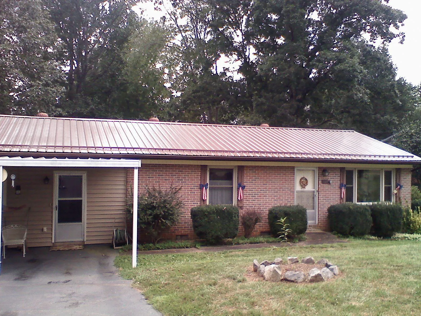 Bronze metal roof and carport on a brick ranch home — Roof Repair work by our crew in Salt Lick
